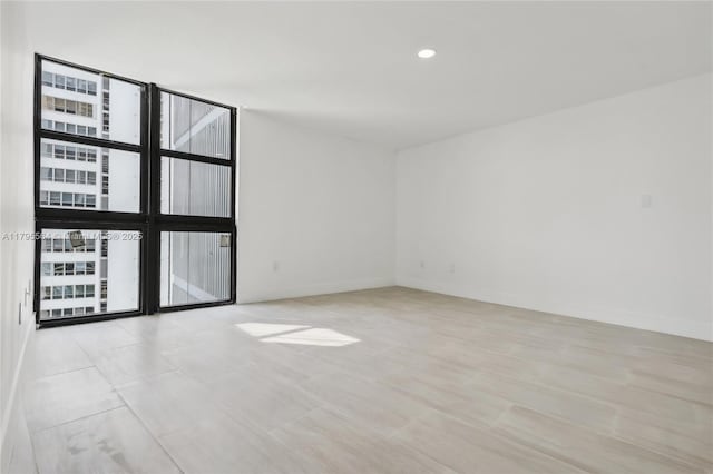 unfurnished room with baseboards and recessed lighting