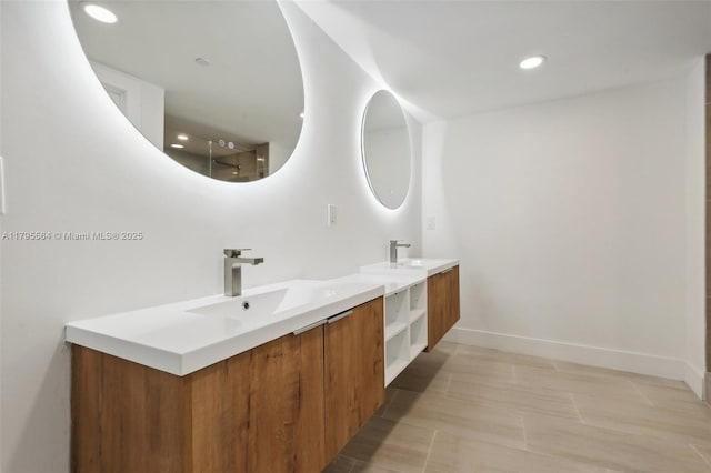 full bath with recessed lighting, baseboards, two vanities, and a sink