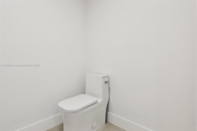bathroom with baseboards and toilet