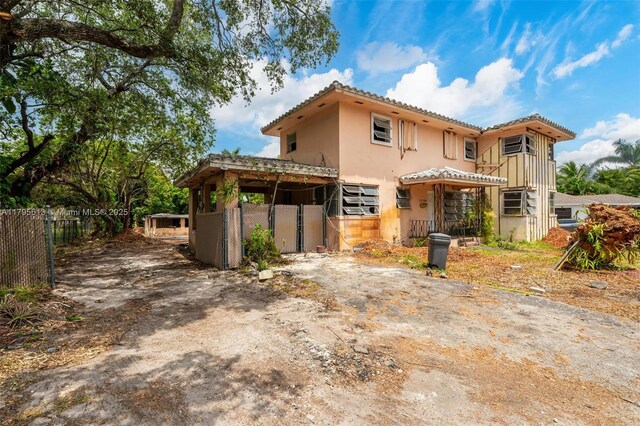 15100 NW River Dr, Miami, FL 33169 - rear view of house featuring a tile roof, stucco siding, and driveway