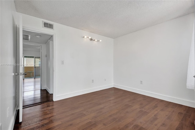 665 NW 85th Pl Unit 10-205, Miami, FL 33126 - spare room with baseboards, dark wood-type flooring, a textured ceiling, and visible vents