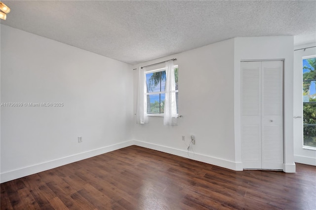 unfurnished room featuring baseboards, a healthy amount of sunlight, and wood finished floors
