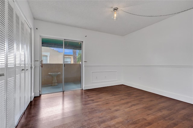 unfurnished bedroom featuring wainscoting and wood finished floors