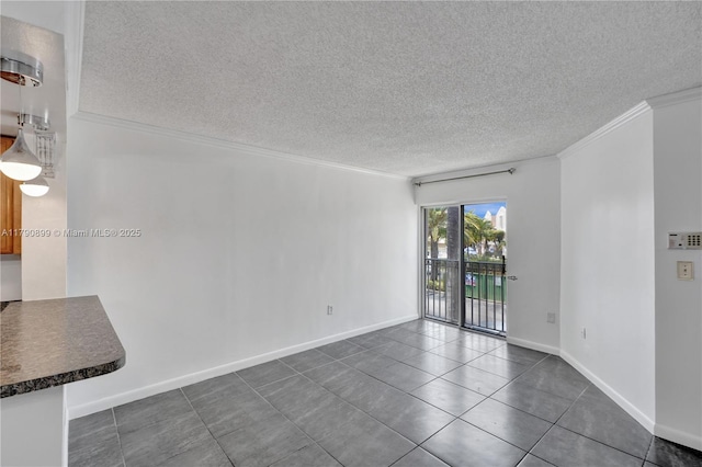 unfurnished living room with crown molding, dark tile patterned flooring, a textured ceiling, and baseboards