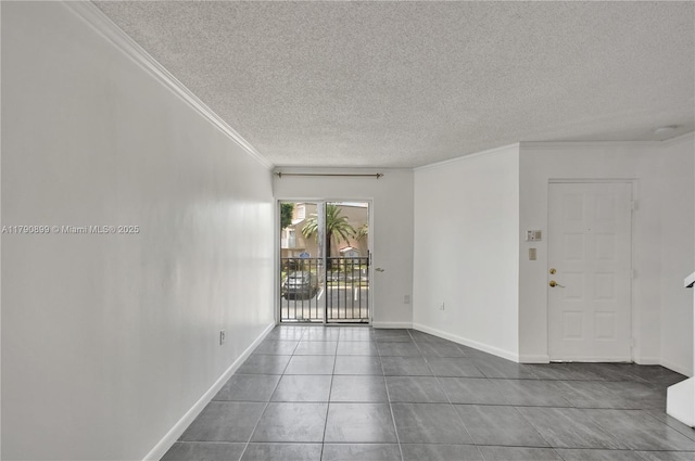 empty room with tile patterned flooring, a textured ceiling, crown molding, and baseboards