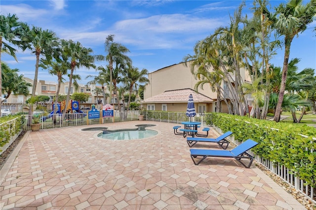 view of swimming pool featuring a patio, a hot tub, and fence