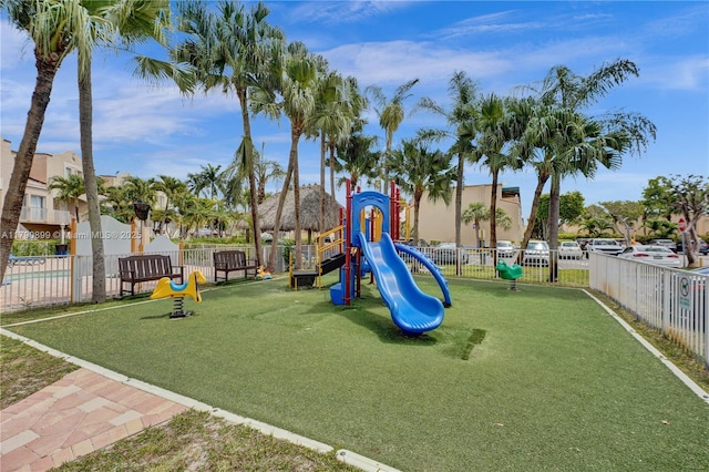 community playground featuring a yard and fence