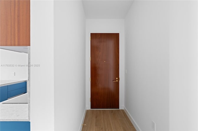 hallway featuring baseboards and light wood-style flooring