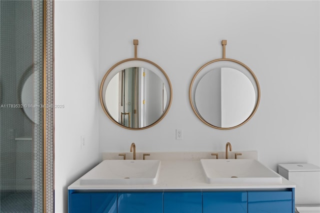 bathroom featuring double vanity, toilet, an enclosed shower, and a sink