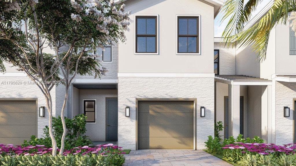 view of front of property with an attached garage, stucco siding, and driveway