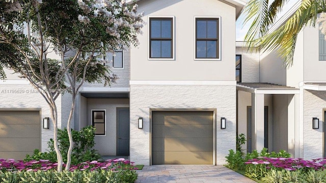view of front of property with an attached garage, stucco siding, and driveway