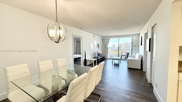 3300 NE 192nd St Unit Ph09, Aventura, FL 33180 - dining space featuring a textured ceiling, a chandelier, dark wood-style floors, and baseboards