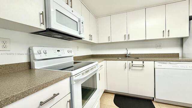 3300 NE 192nd St Unit Ph09, Aventura, FL 33180 - kitchen with white appliances, a sink, dark countertops, and white cabinetry