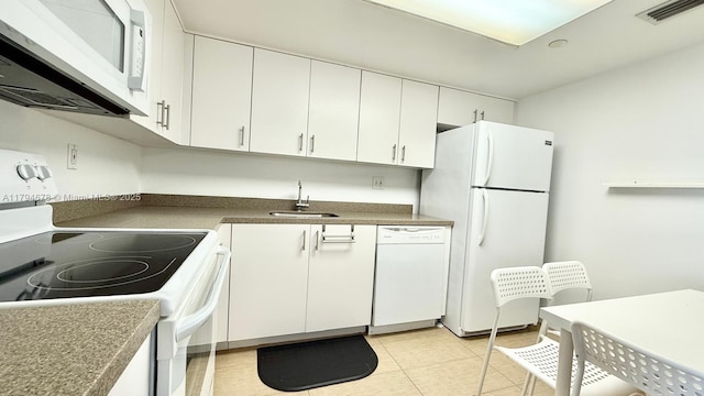 3300 NE 192nd St Unit Ph09, Aventura, FL 33180 - kitchen with white appliances, a sink, white cabinets, light tile patterned floors, and dark countertops