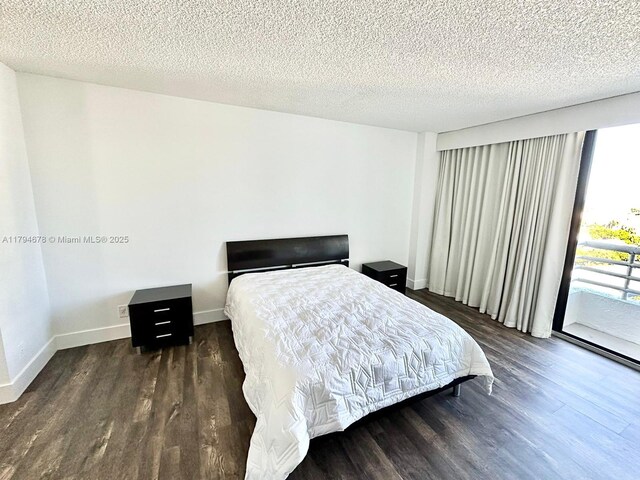 3300 NE 192nd St Unit Ph09, Aventura, FL 33180 - bedroom featuring wood finished floors, access to outside, baseboards, and a textured ceiling