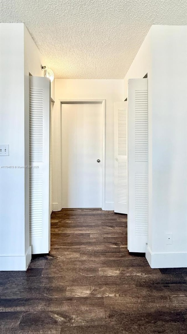 3300 NE 192nd St Unit Ph09, Aventura, FL 33180 - unfurnished bedroom featuring wood finished floors, a textured ceiling, baseboards, and a closet