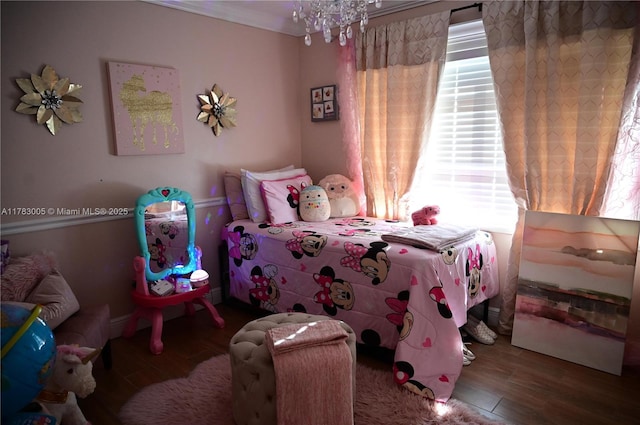 bedroom featuring wood finished floors, a notable chandelier, and multiple windows