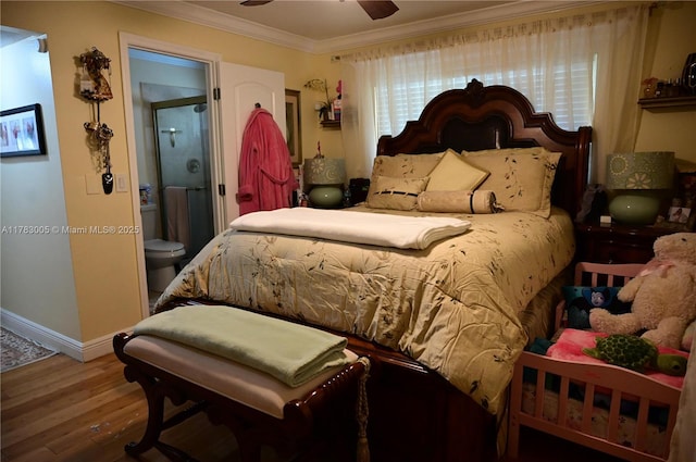 bedroom with baseboards, ornamental molding, ensuite bath, and wood finished floors