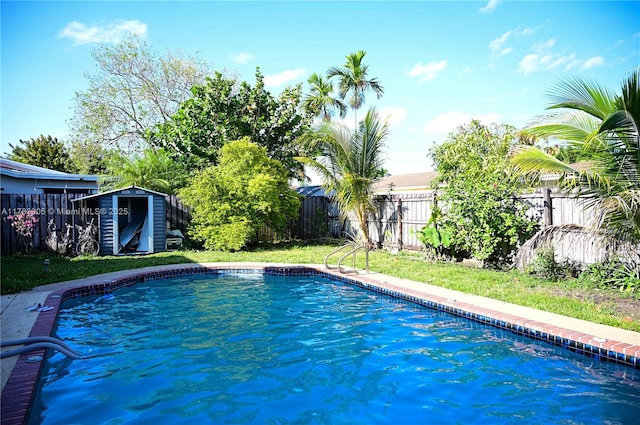 view of swimming pool featuring a fenced backyard, a storage unit, an outbuilding, and a fenced in pool