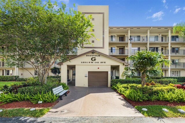 1351 SW 141st Ave Unit 313G, Pembroke Pines, FL 33027 - view of building exterior with an attached garage and driveway