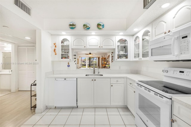 kitchen featuring a sink, glass insert cabinets, white appliances, and visible vents