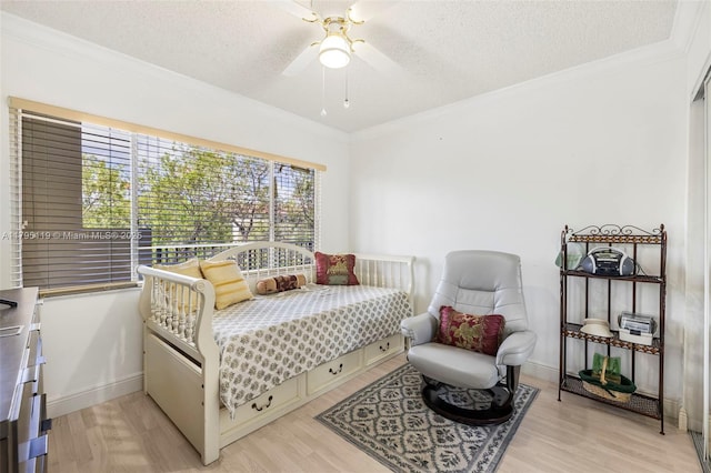 bedroom featuring crown molding, a ceiling fan, a textured ceiling, and light wood-type flooring