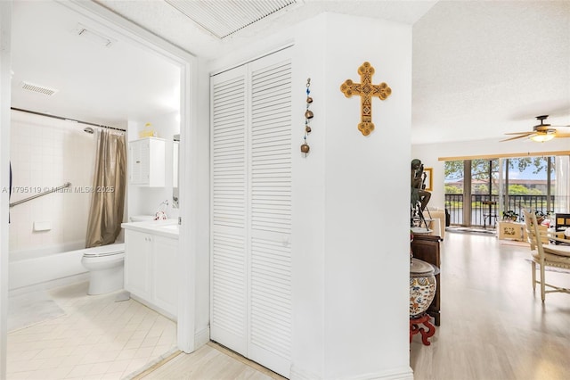 bathroom featuring ceiling fan, visible vents, shower / tub combo, a closet, and toilet
