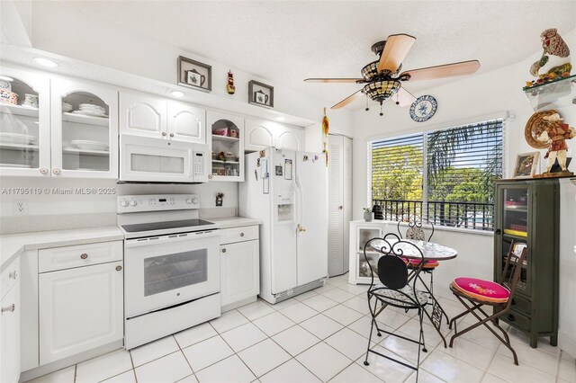 1351 SW 141st Ave Unit 313G, Pembroke Pines, FL 33027 - kitchen featuring white appliances, a ceiling fan, light countertops, glass insert cabinets, and a textured ceiling