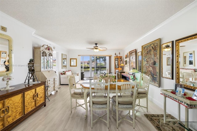 dining space with a ceiling fan, a textured ceiling, crown molding, baseboards, and light wood-style flooring