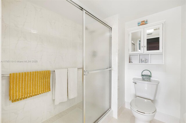 1351 SW 141st Ave Unit 313G, Pembroke Pines, FL 33027 - full bath featuring toilet, a shower stall, baseboards, and tile patterned flooring