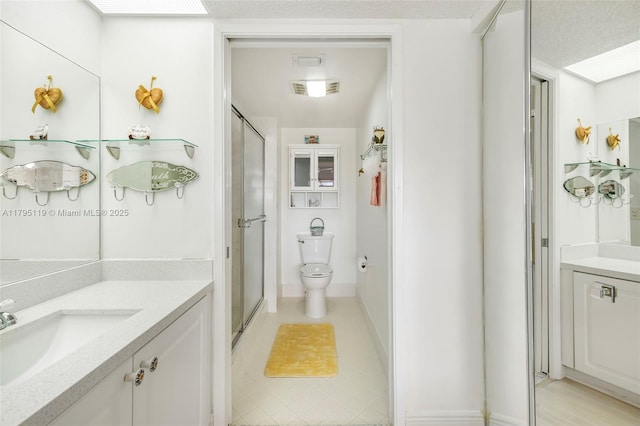 bathroom with vanity, visible vents, toilet, and a shower stall