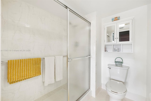 bathroom with baseboards, a stall shower, and toilet