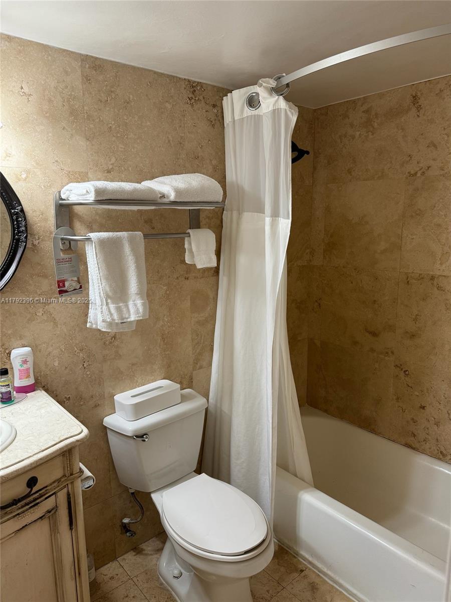 19201 Collins Ave Unit 831, Sunny Isles Beach, FL 33160 - full bath with toilet, tile walls, shower / bath combination with curtain, and vanity