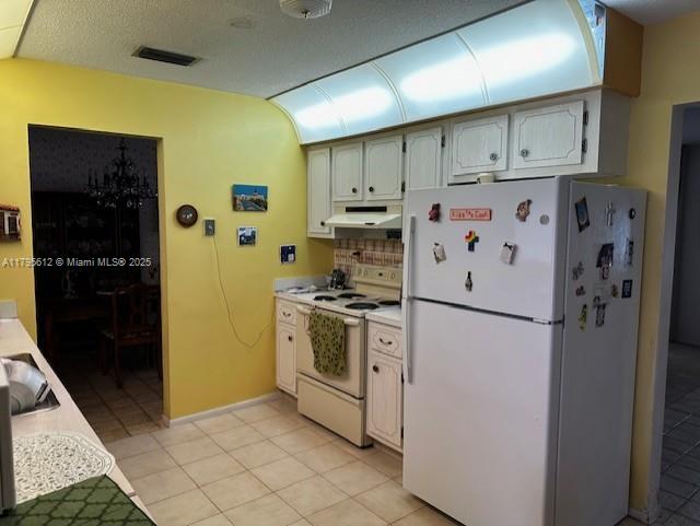 7206 NW 89th Ave, Tamarac, FL 33321 - kitchen featuring white appliances, exhaust hood, light countertops, decorative backsplash, and light tile patterned flooring