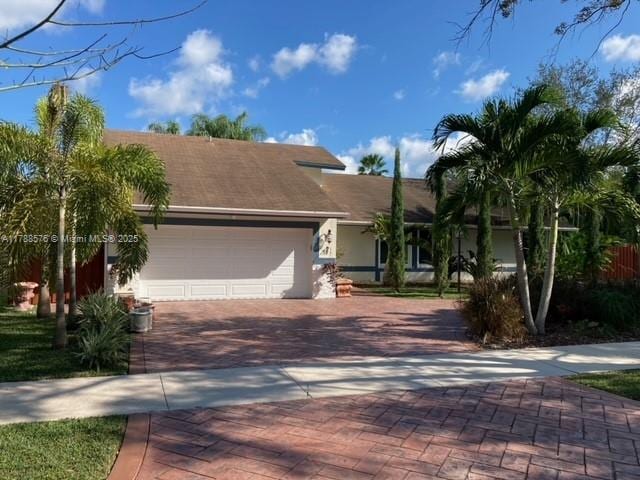 view of front of house featuring a garage, stucco siding, and decorative driveway