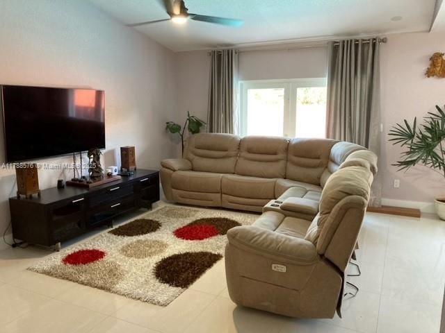 living area with tile patterned floors and a ceiling fan