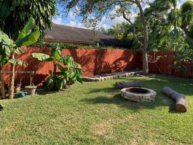 view of yard with a fire pit and a fenced backyard