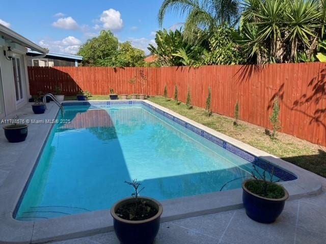view of swimming pool with a fenced backyard, a fenced in pool, and a patio area