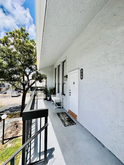 property entrance featuring covered porch and stucco siding