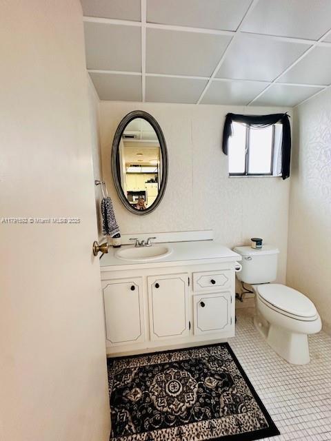 bathroom with toilet, tile patterned flooring, and vanity