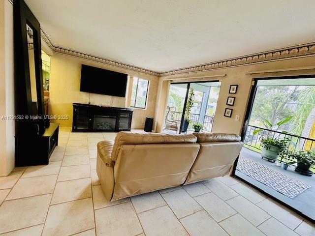 living room with a glass covered fireplace and light tile patterned floors