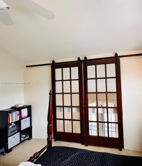 unfurnished bedroom featuring a barn door and carpet