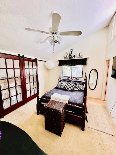bedroom featuring carpet floors, a ceiling fan, and lofted ceiling