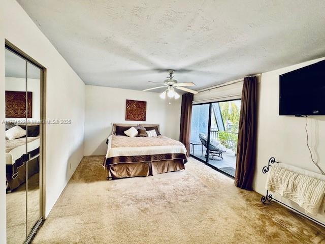 carpeted bedroom featuring a ceiling fan, a textured ceiling, and access to exterior