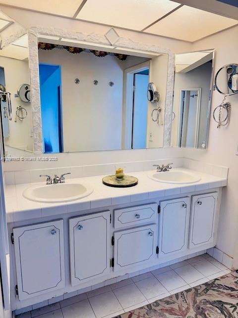 bathroom with double vanity, a sink, and tile patterned floors