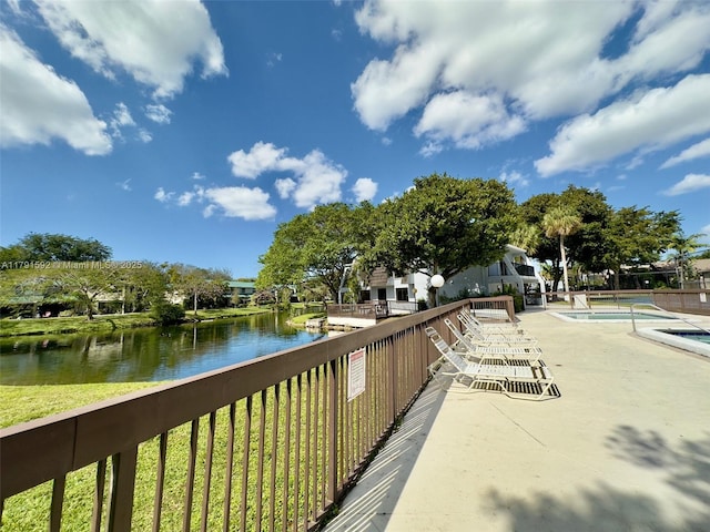 exterior space with a water view, a patio, and a pool