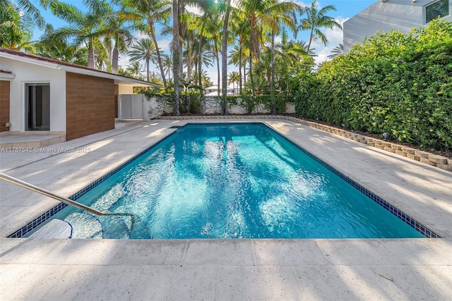 pool with a fenced backyard and a patio area