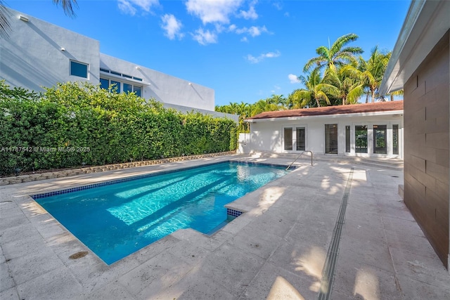 view of swimming pool with a patio, french doors, and a fenced in pool