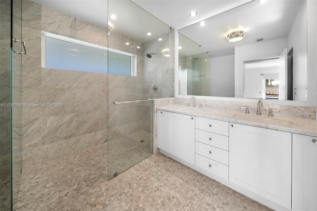full bath with a sink, a wealth of natural light, and tiled shower