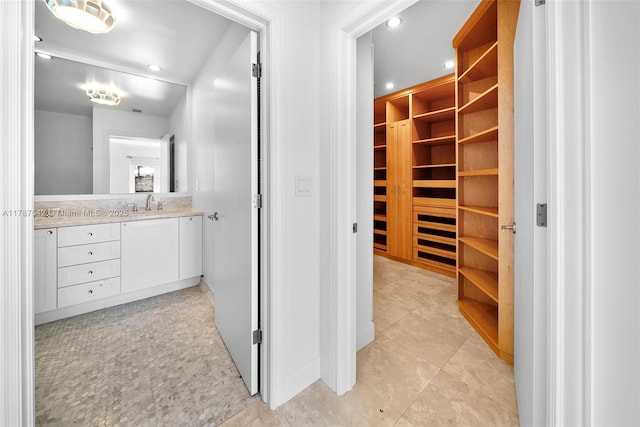 walk in closet with light tile patterned floors and a sink